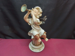 A vintage cherub resin figurine featuring an angel playing a musical horn.H.35 W.17 Cm.