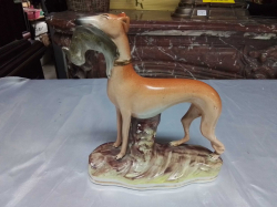 An Early 19th Century model of a Greyhound holding a rabbit in its mouth (Old repair to rearleg) W.18 H.21 Cm.