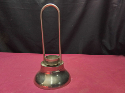 A vintage metal tea light holder with a Tall looped handle