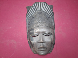 A heavy hand carved wooden African tribal mask detailed facial features and headdresses wall hanging marked no.6824-HN-144. Approx size W.23 cm H.43 cm