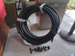 A lage coil of heavy black water piping with fittings 