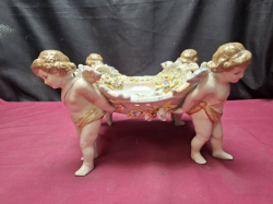 A Beautiful centerpiece Putti 4 cherubs holding a porcelain dish with many flowwers inside & outside in mint condition possibly German