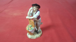 A Sitzendorf figurine of man selling apples 13cm high 