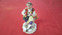 A Sitzendorf figurine of man selling birds 14cm high
