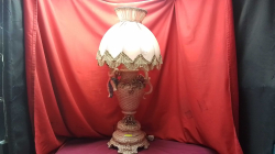 A Ceramic table Lamp with Flowers and a putting with a silk shade.
H80cm.
W21cm. 