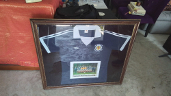 A Professional Framed 1978 Scotland world cup shirt with signed team ohotograph. Dimensions 100x87 cm