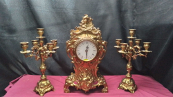 A Brass clock with 2 fiuk branch garnatures Candle sticks.
H43cm. W22cm.