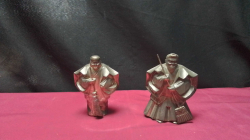 A Pair of Takasago dolls which are traditional Japanese figures of a old couple from the noh prayer of Longevity and happy lasting marriage one holds a rake to gather good fortune the other holds a broom to sweep away evil.