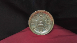  a decorative round plate made of tibetan silver featuring a embossed relief of shakyamuni budha seated in the centre surrounded by the 8 auspicious treasures has a quinlong mark to base and the base is decorated with dragons

